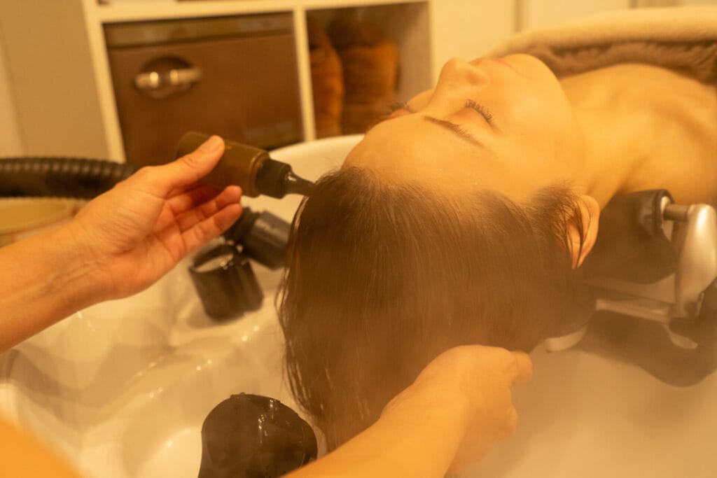 尼崎のヘッドスパサロンnemuruのオリジナルエッセンスでマッサージしている様子